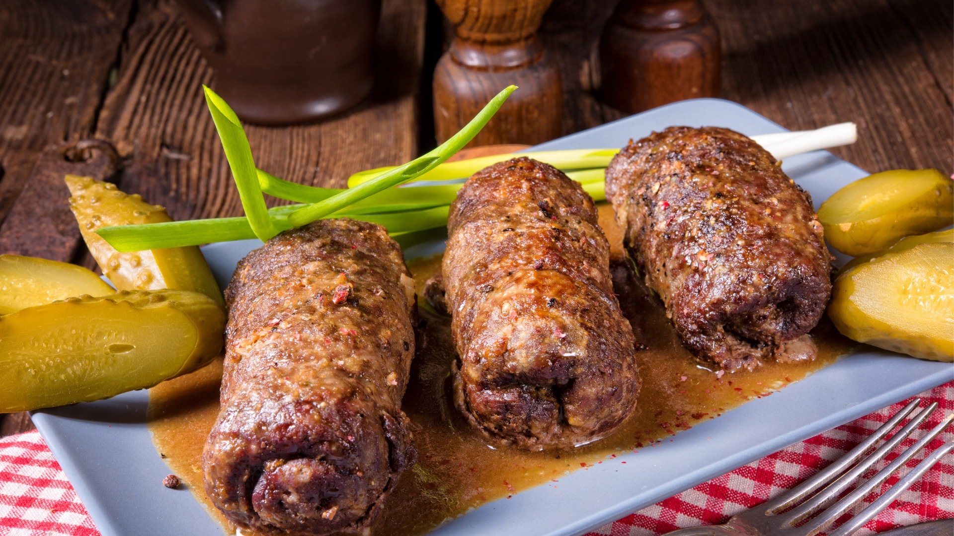 Three Rouladen served with pickled cucumbers. The best German food for a Sunday lunch with the family. 