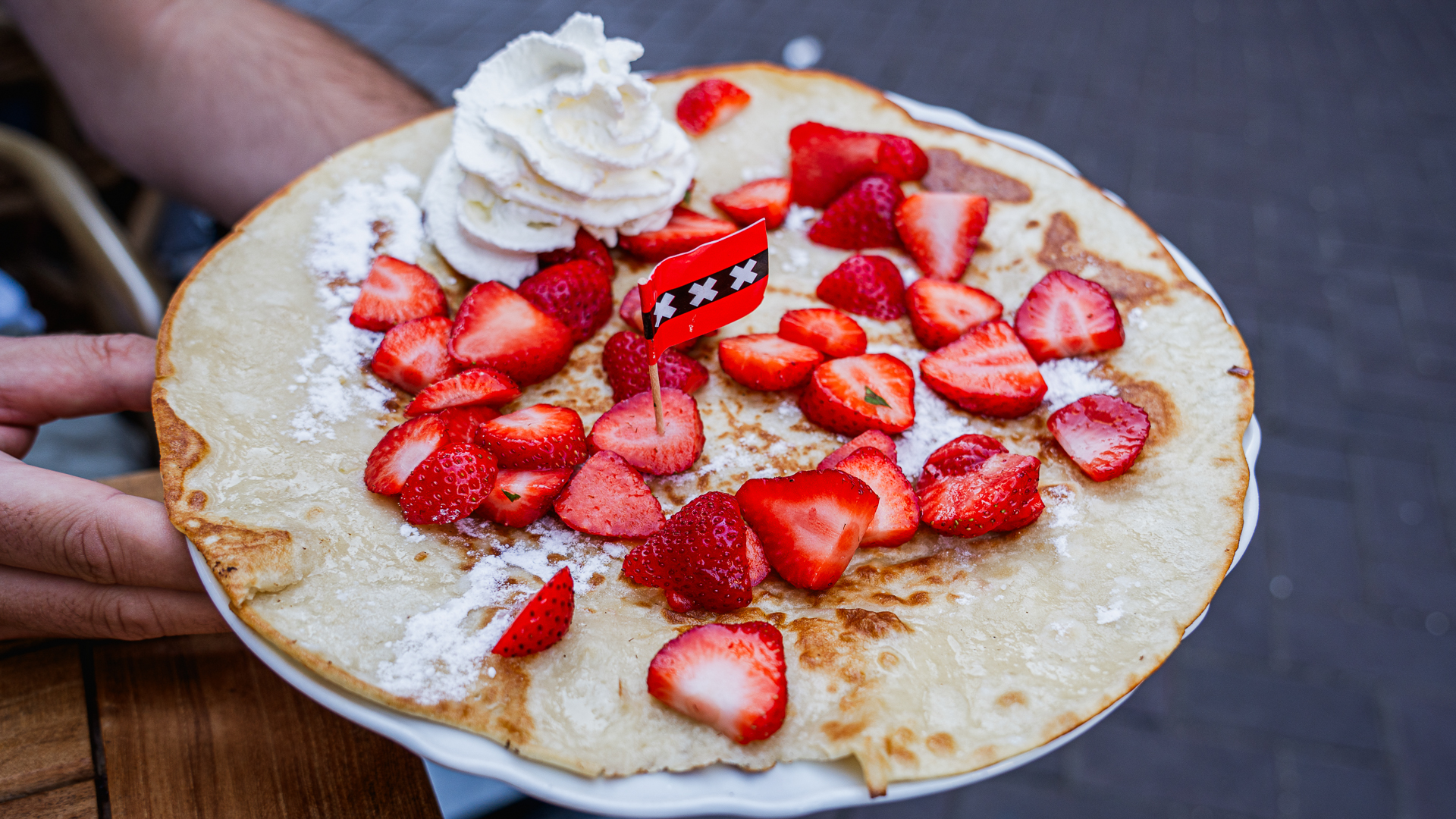 Pannenkoek - Dutch pancake topped with halved strawberries and whipped cream. 