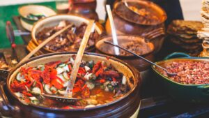 Several clay pots filled with various types of traditional Hungarian food.