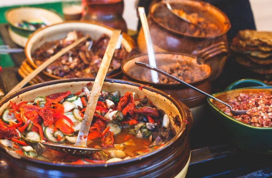 Several clay pots filled with various types of traditional Hungarian food.