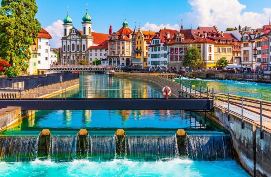 A row of beautiful buildings in the background and a river in the foreground on a bright summer day.