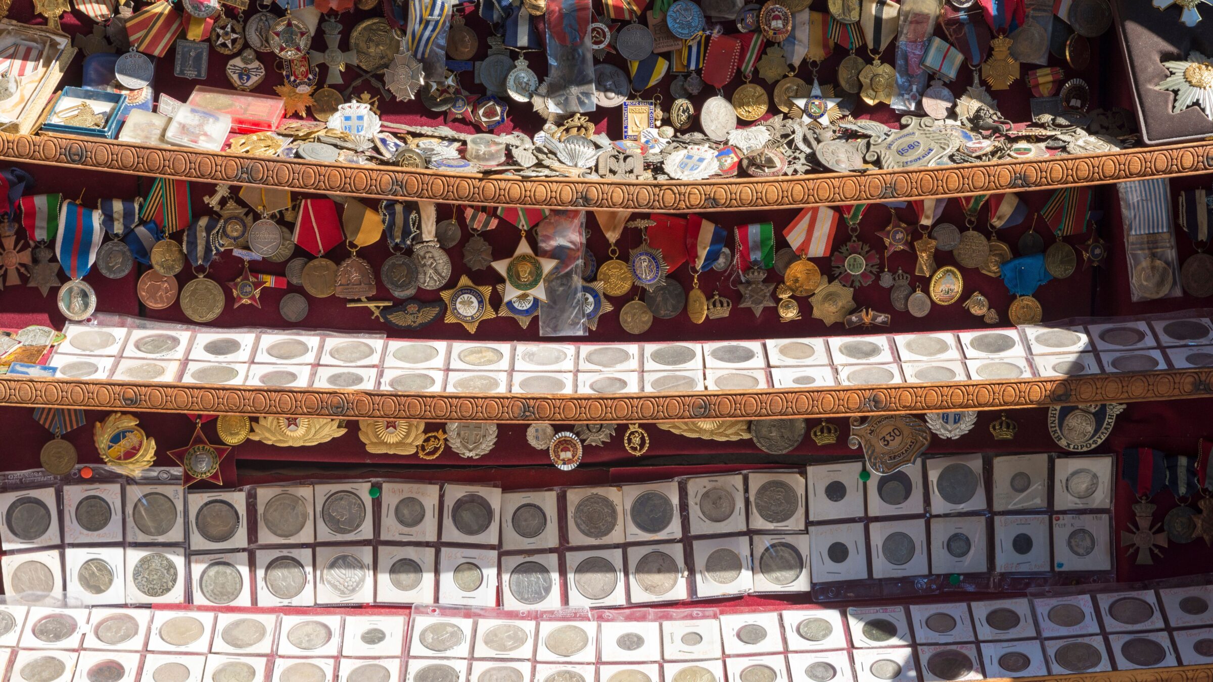 Old pins and coins on a flea market stall. 