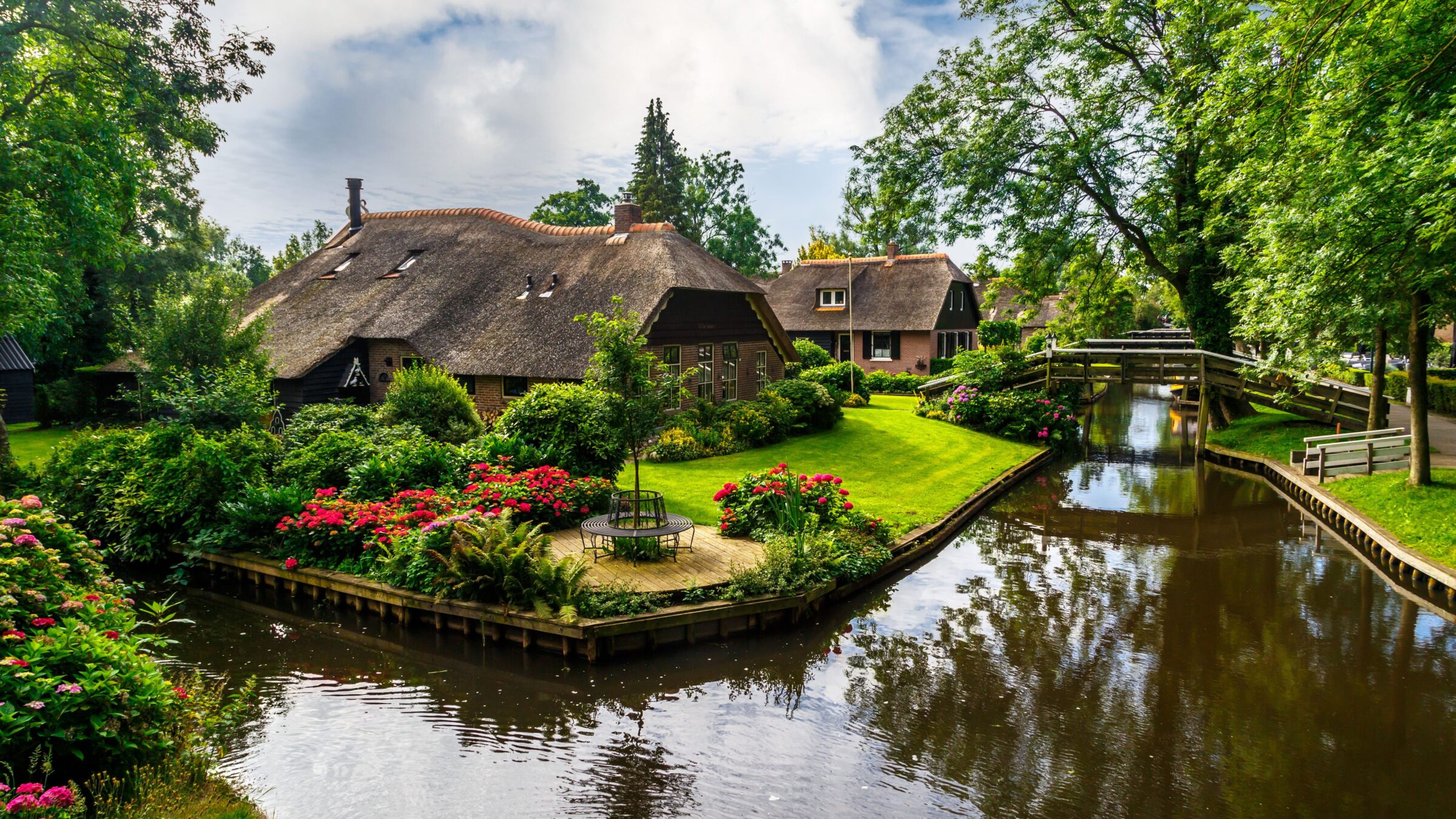 Landscape view of the famous Giethoorn village with its canals and rustic thatched roof houses.
