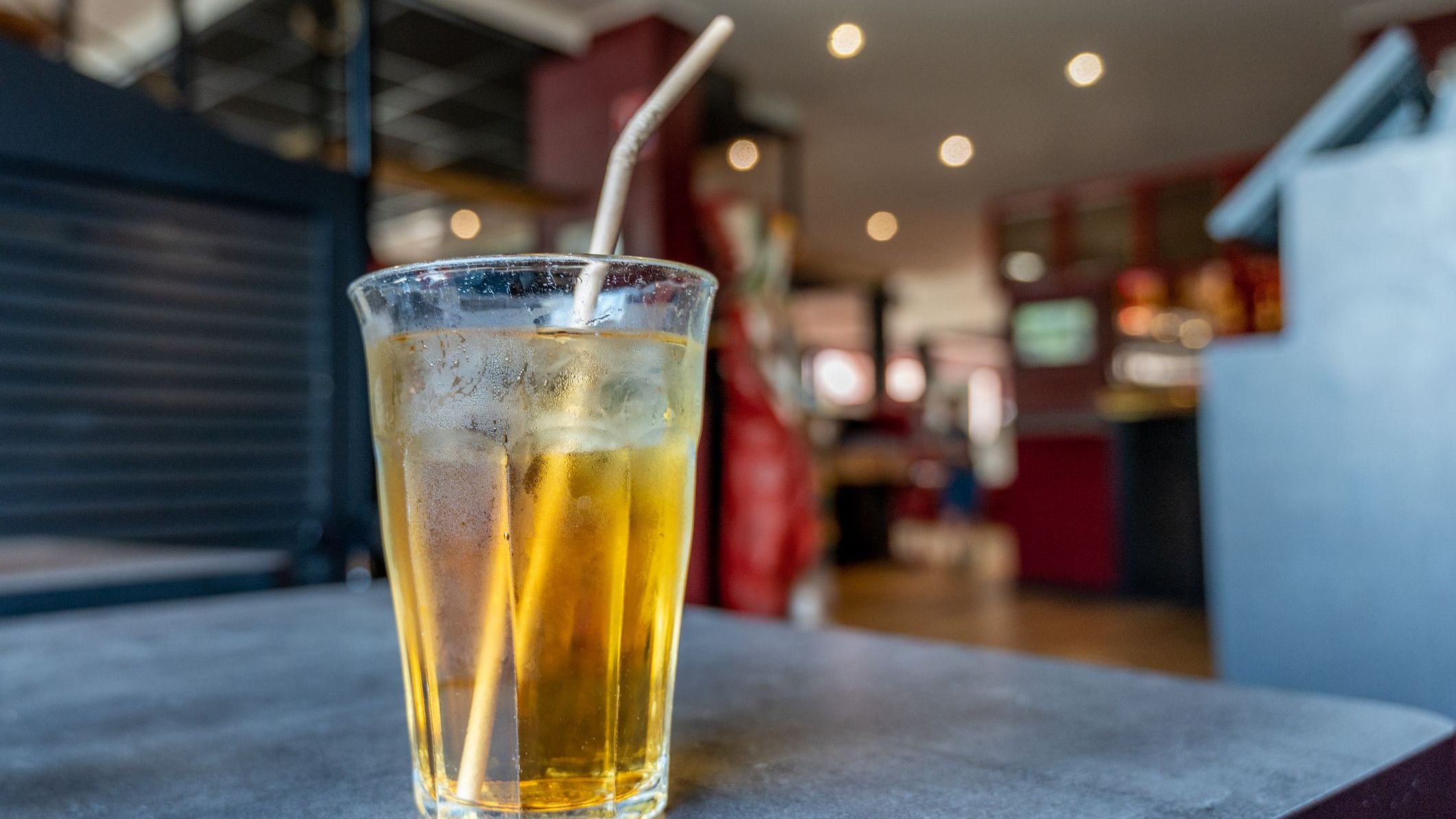 A glass of a light brown soda drink on a table.