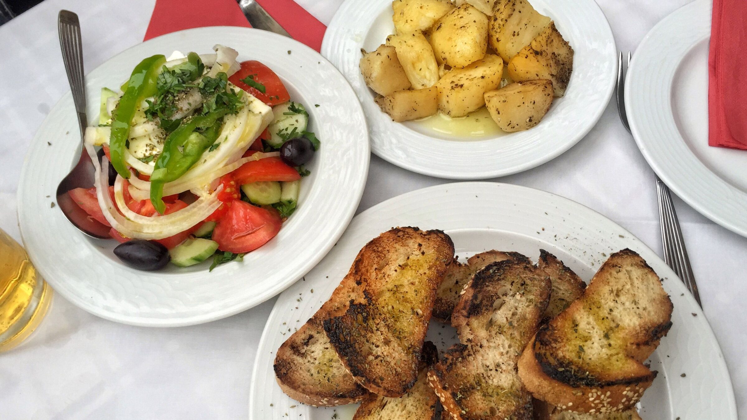 A delicious Greek salad and appetizers on a table.