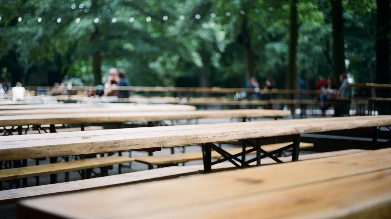 The empty tables of a beer garden in the daytime.