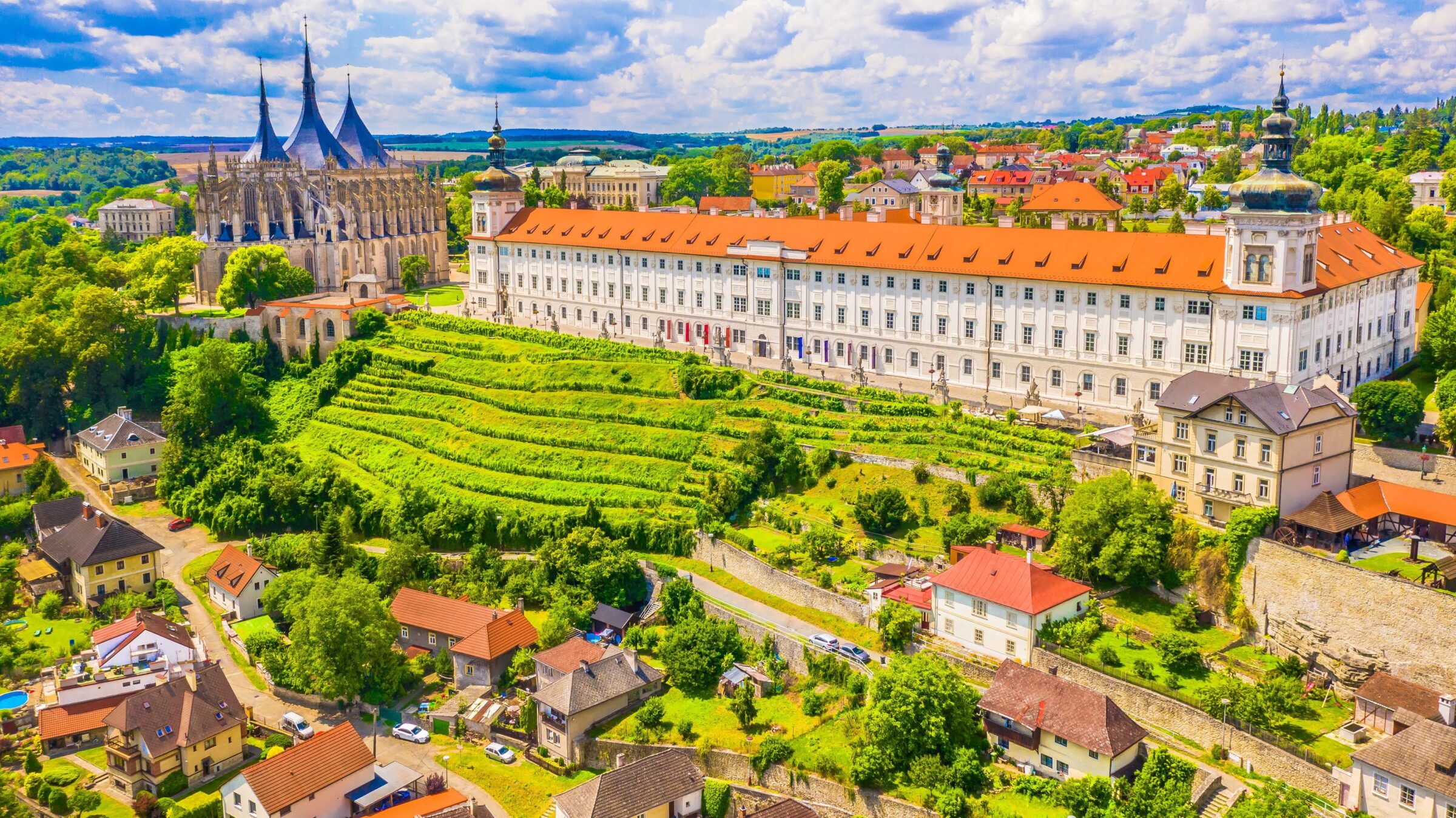 A stunning view of the historic castles and landscape of Kutna Hora, showcasing medieval architecture surrounded by lush greenery, highlighting the town’s rich architectural heritage.