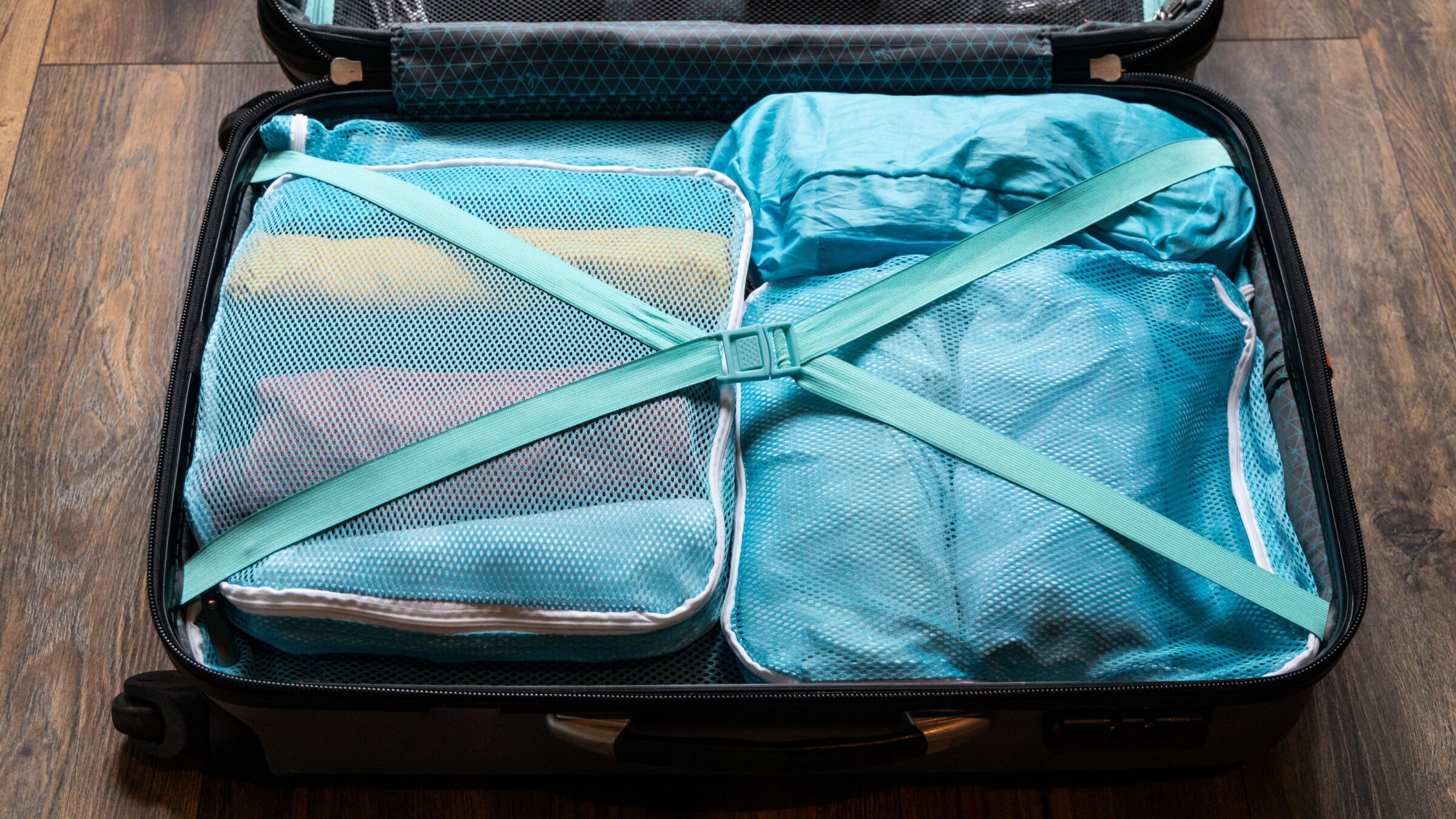 Clothes rolled and packed in packing cubes in a suitcase.