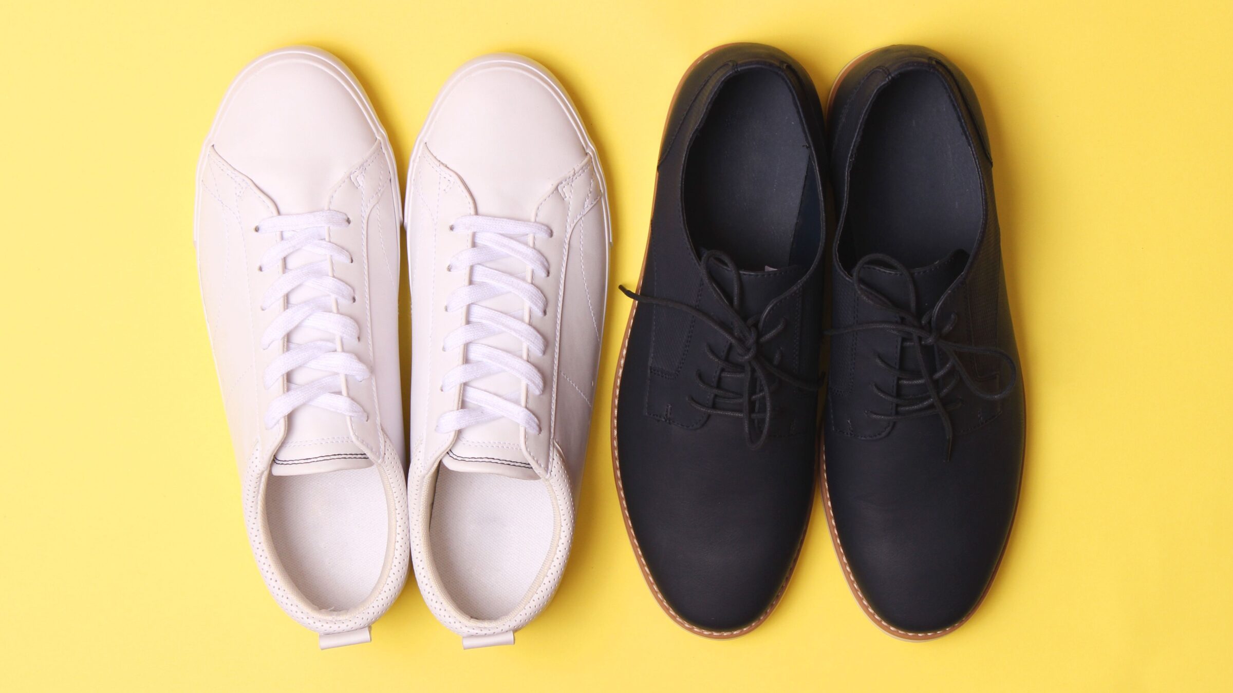 Men's office shoes and sneakers on a yellow background.