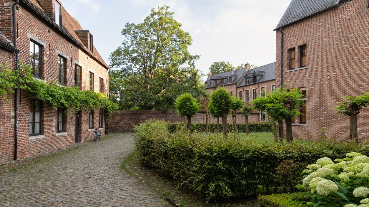 Brick-walled houses, cobbled streets and trees.
