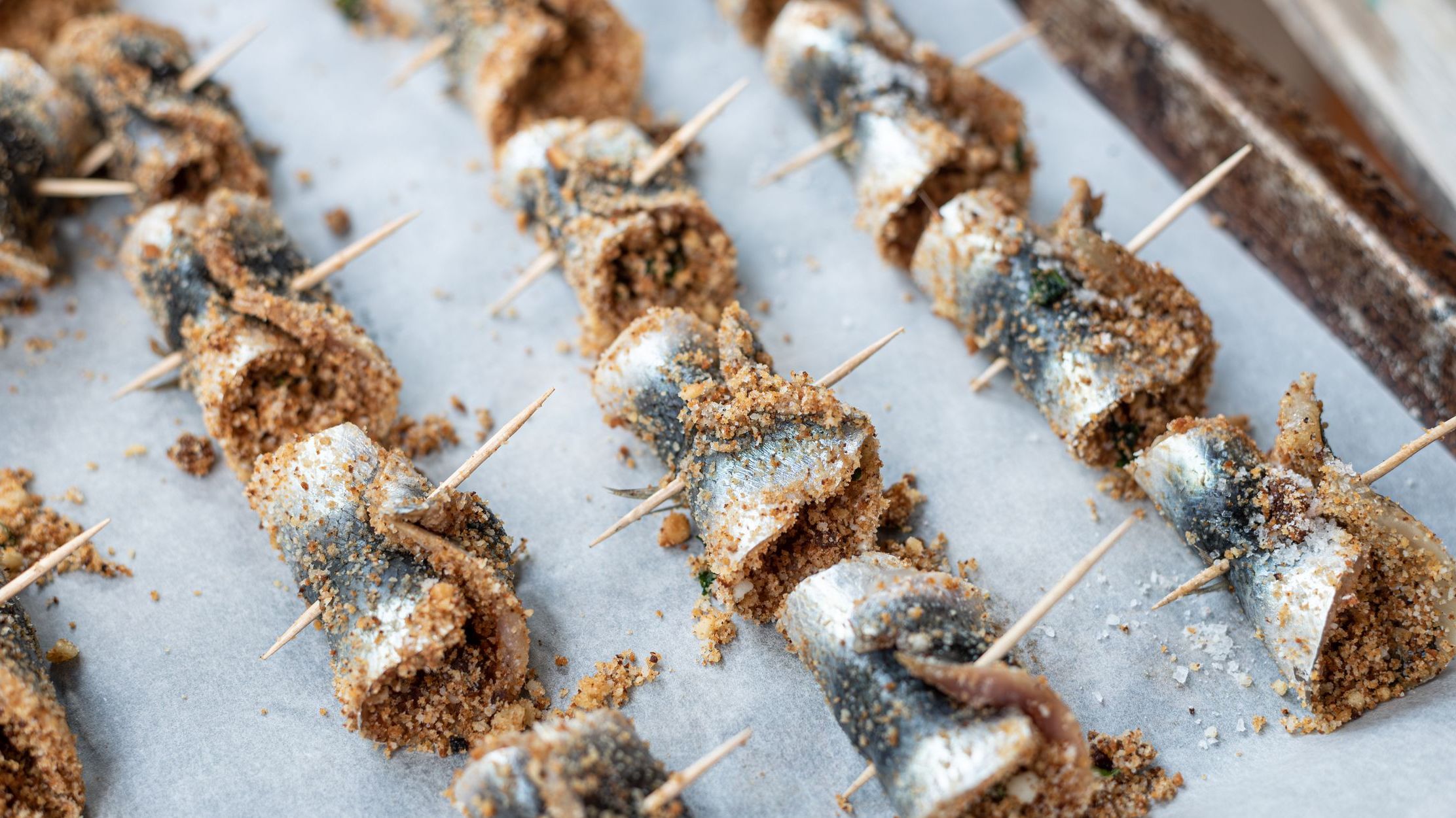 Baked rolled sardines stuffed with pine nuts, breadcrumbs, raisins, salt and pepper. 