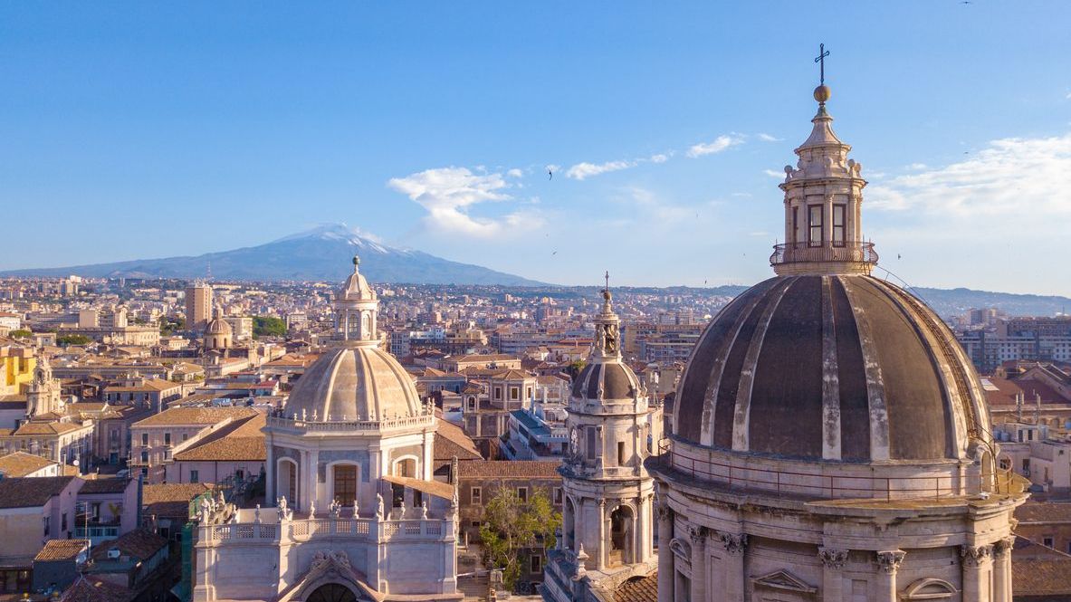 A beautiful aerial view of Catania near the main Cathedral, with Etna volcano in the background. 