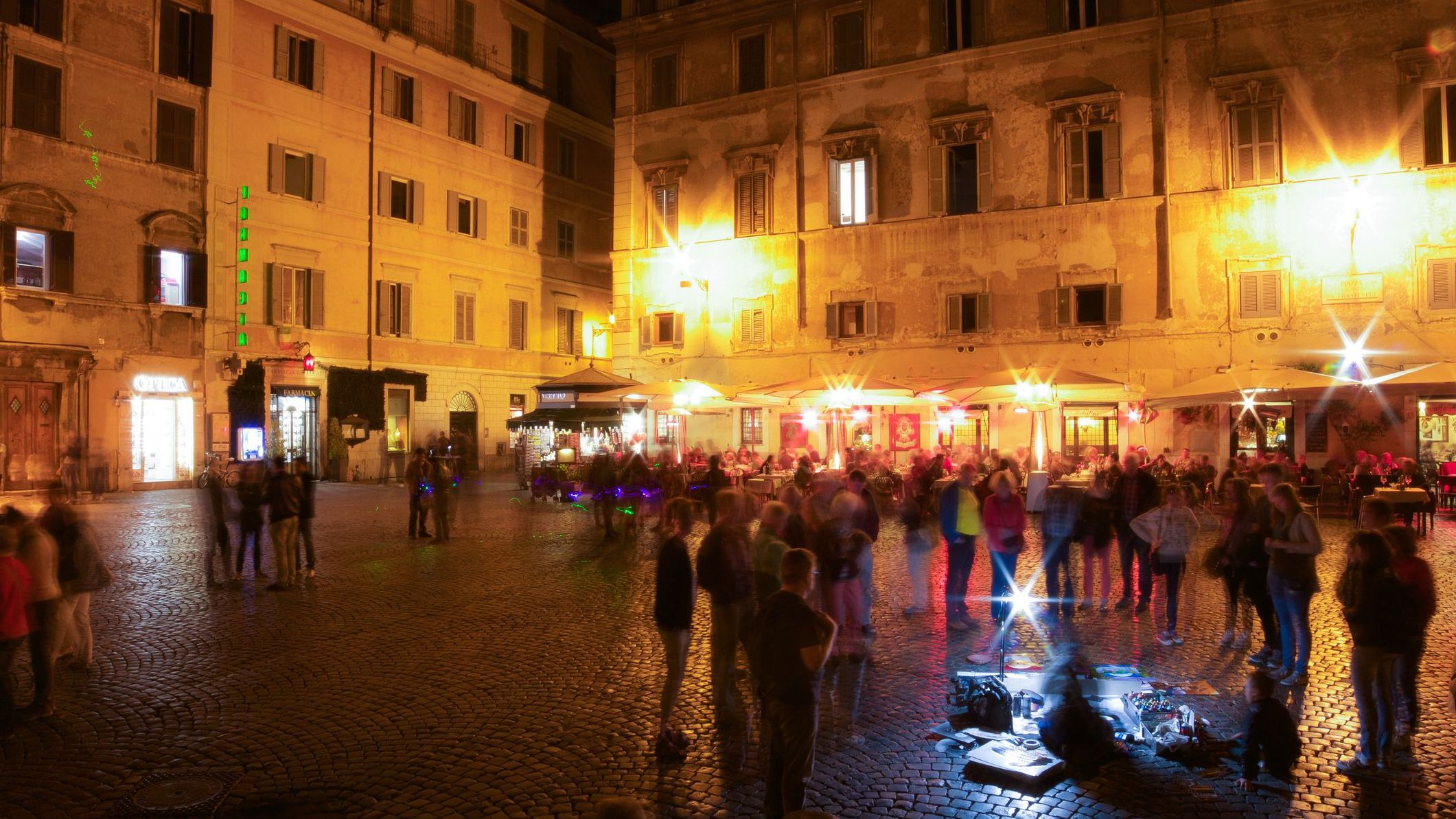 People hanging around on a square at night. 