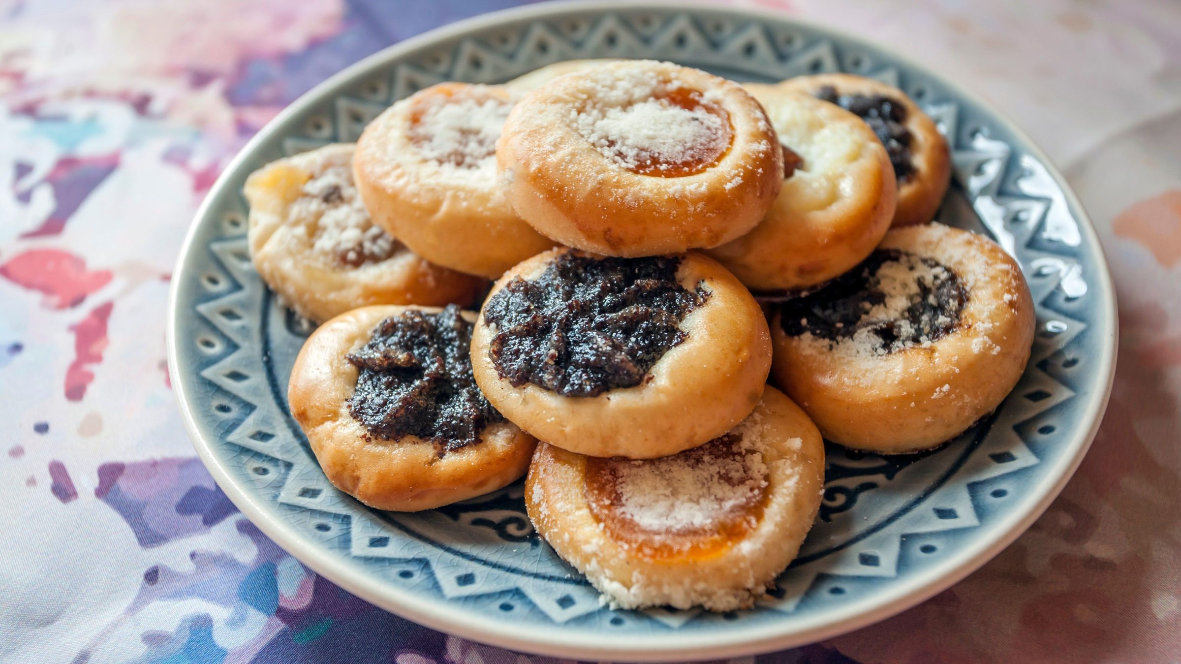 A blue and white plate with many round cookies. 
