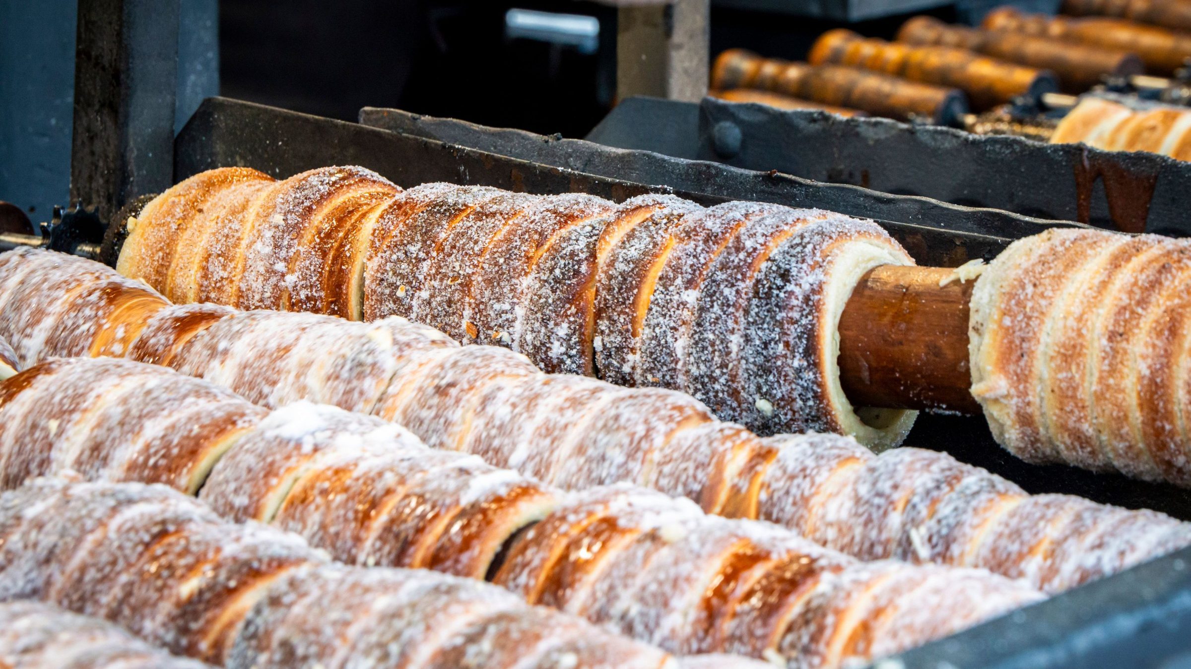 Fresh chimney cakes on spits over an open fire. 