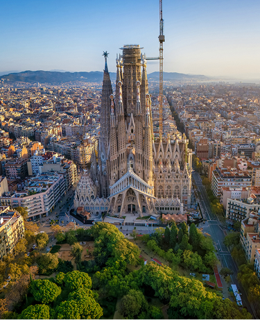 Panoramic aerial view of the famous Sagrada Familia church, in golden sunrise light. Barcelona, Spain