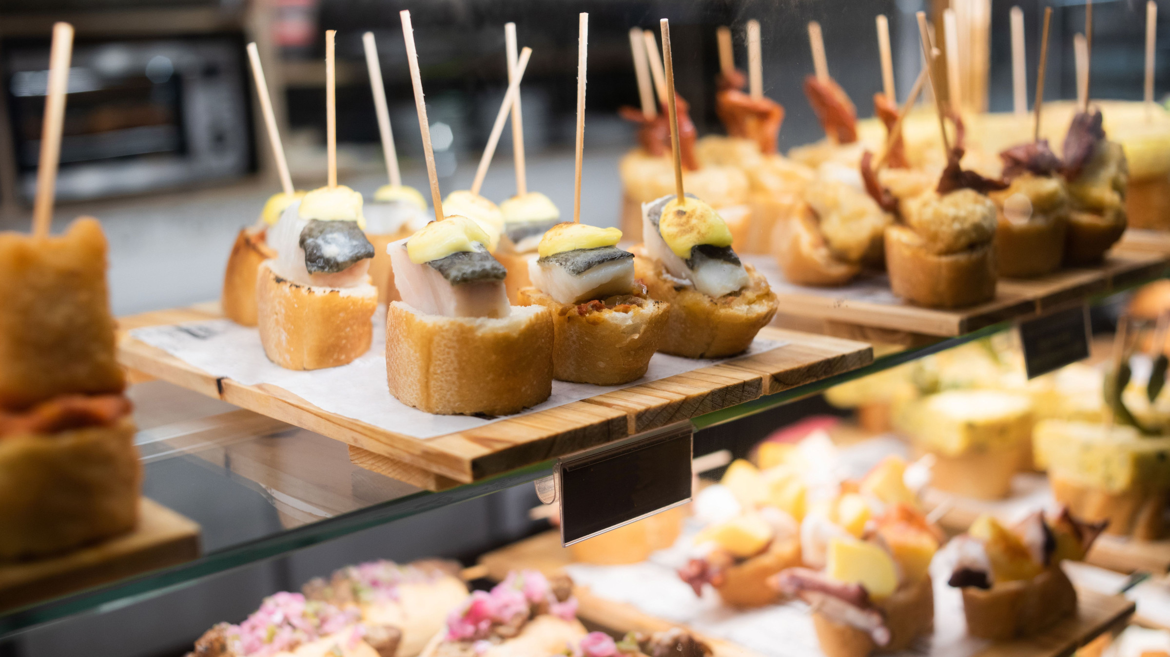 A close-up of bite-sized pieces of bread topped with fish.
