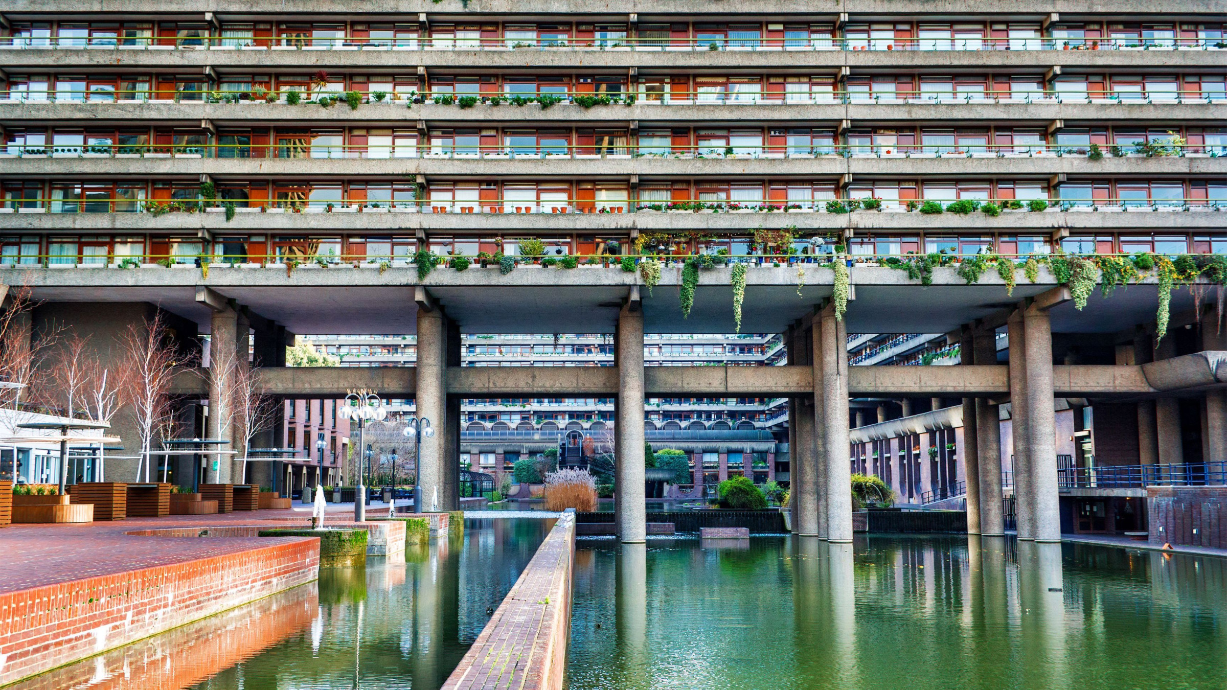 A brutalist construction with a large pond.