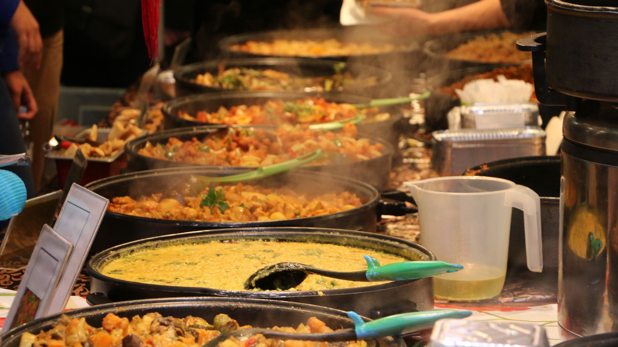 An Indian food stall with several pots of cooked food at Brick Lane Market, London.