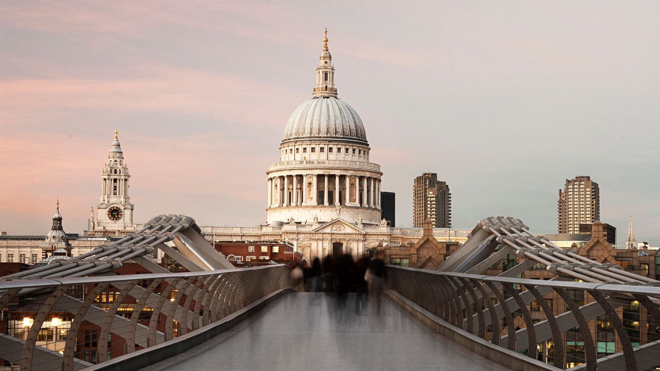 Commuters crossing the Millennium Bridge and walking towards St. Paul's Cathedral.