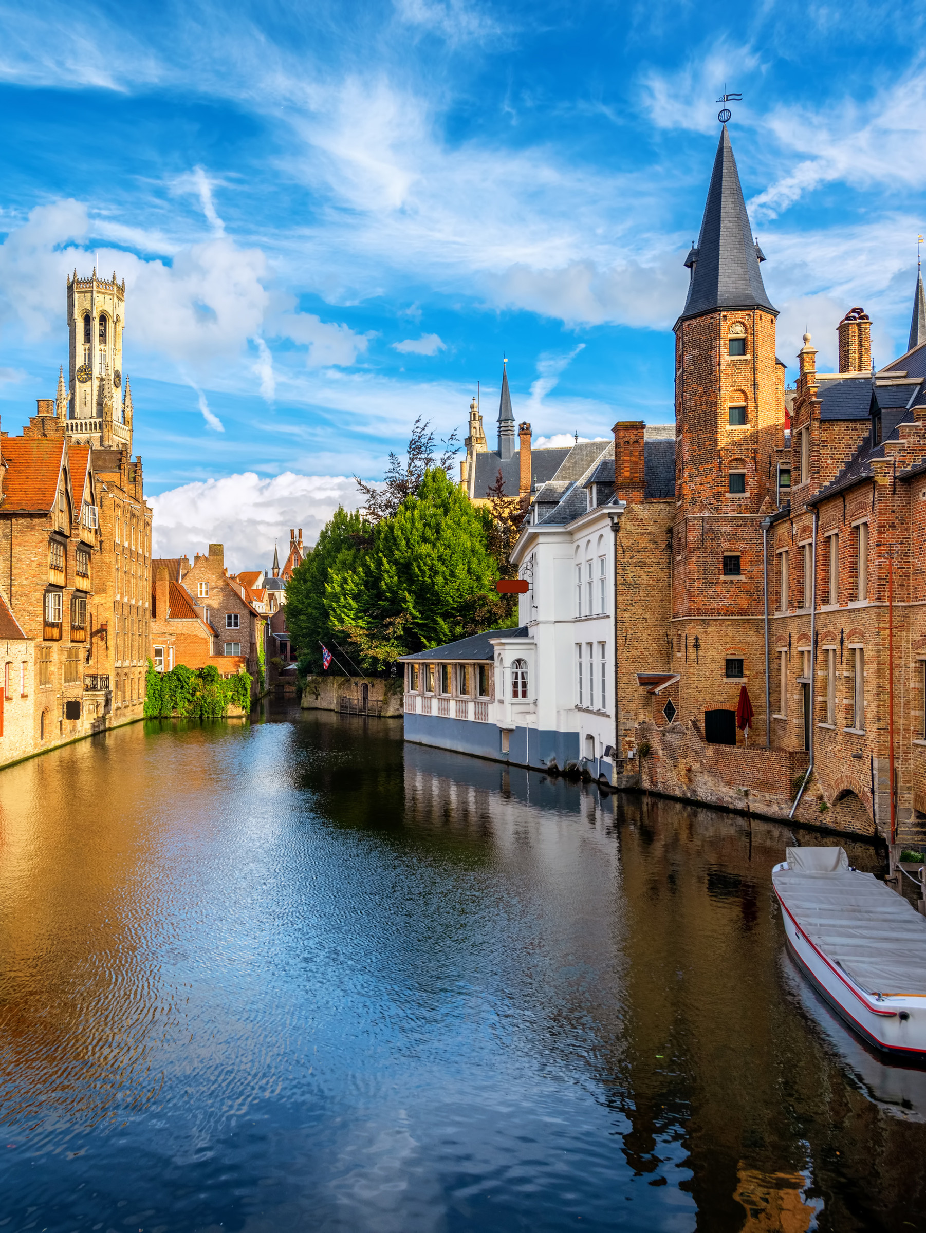The Rozenhoedkaai canal, historical brick houses and the Belfry in Bruges medieval Old Town, Belgium, a UNESCO World Culture Heritage site