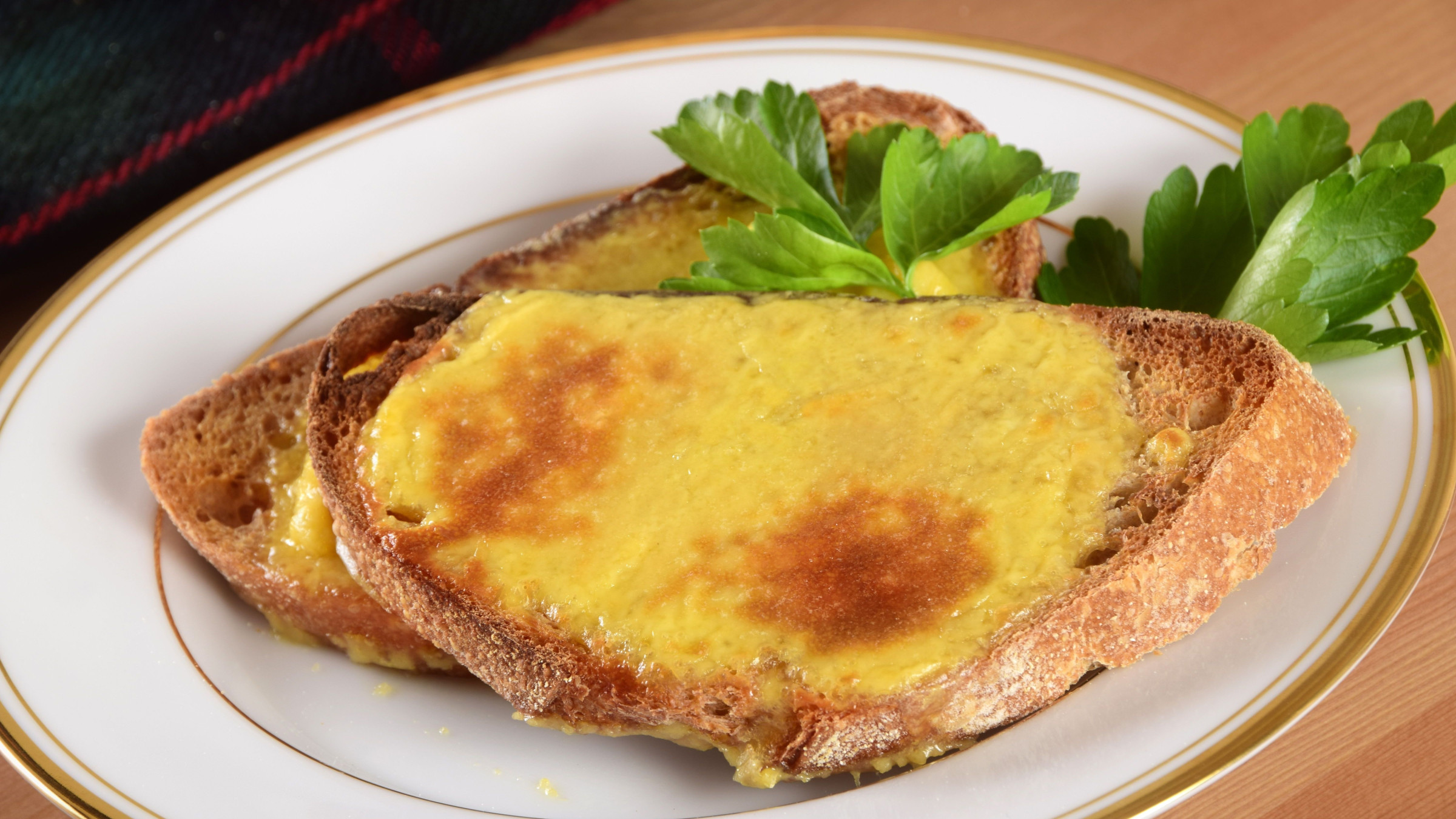 Two slices of bread topped with melted cheese. 
