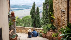 A couple sitting on the steps, enjoying the view of Tuscany's rolling hills.