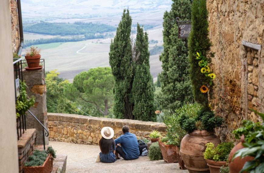 A couple sitting on the steps, enjoying the view of Tuscany's rolling hills.